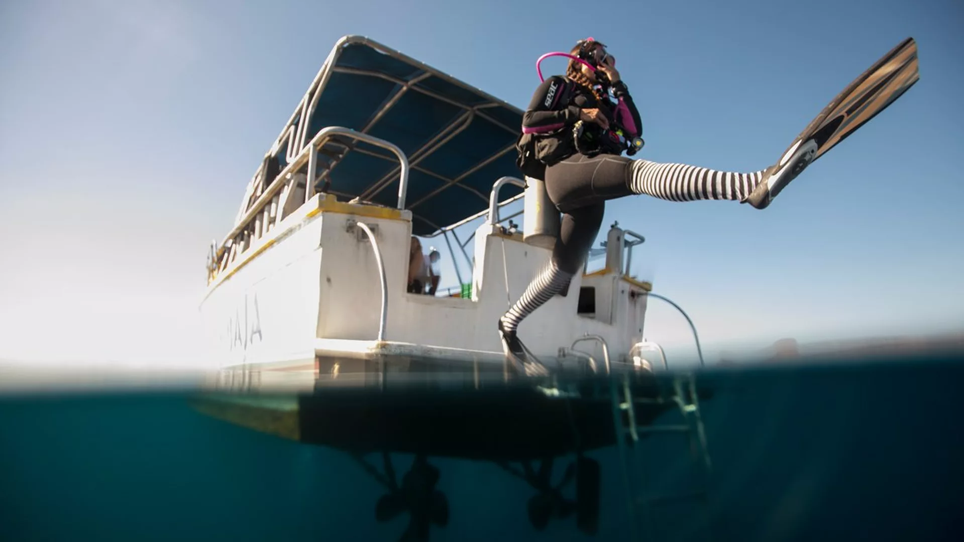 Diver jumping from a boat practicing exiting a boat for a scuba diving Guanacaste tour in Playas Del Coco, Guanacaste, Costa Rica