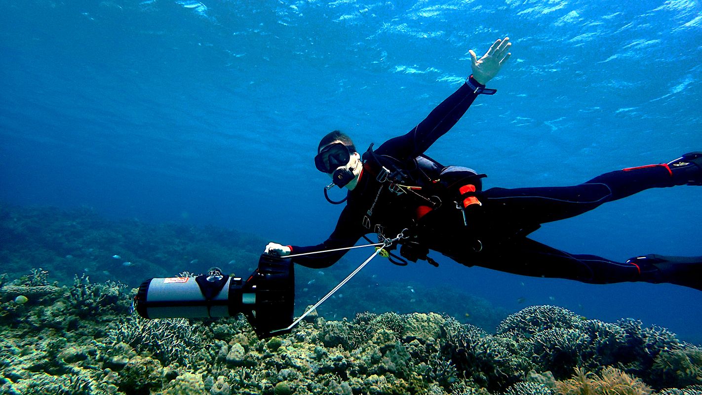 Diver training with a DPV scooter while scuba diving in the Pacific waters of Guanacaste, Costa Rica