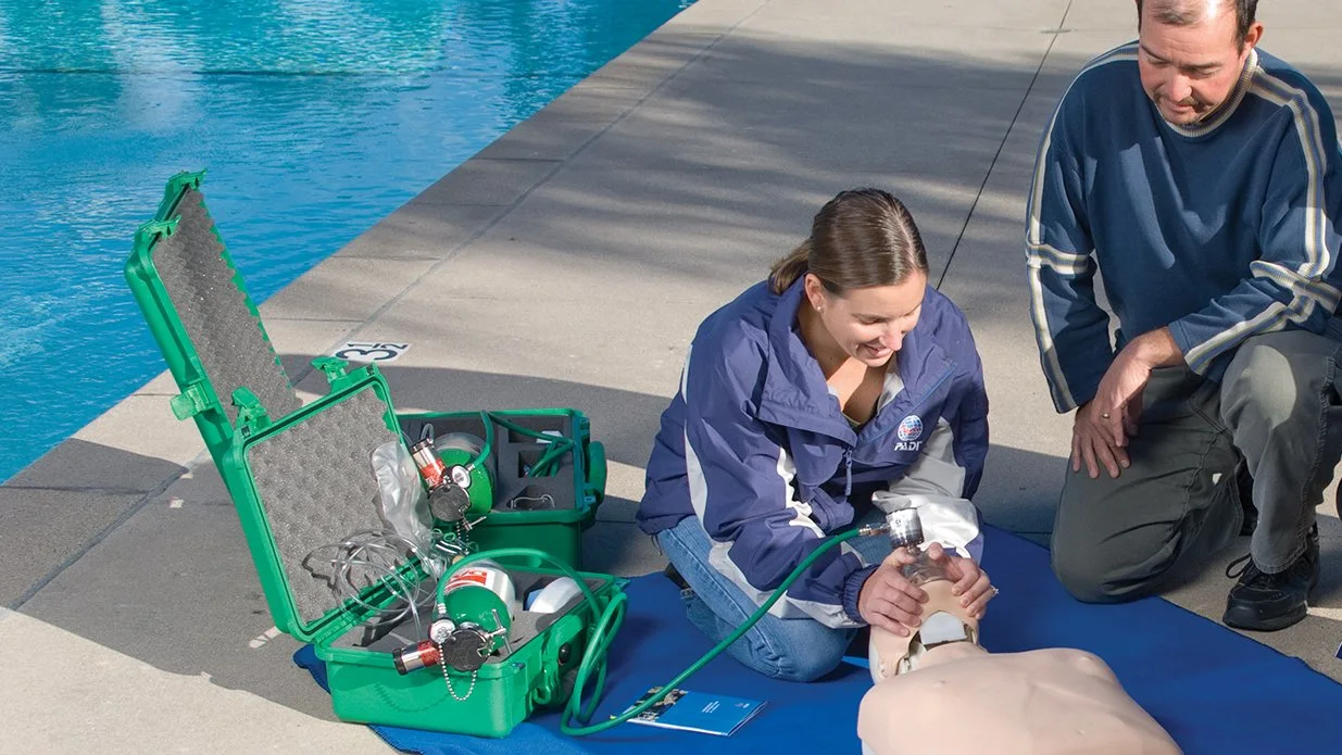 PADI certified instructor showing how to provide Emergency Oxygen to a test dummy near a pool in Playa Potrero, Guanacaste, Costa Rica